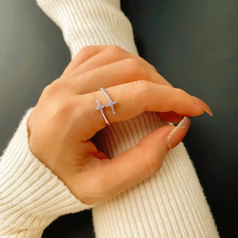 Double Christian cross ring with diamonds on finger of woman