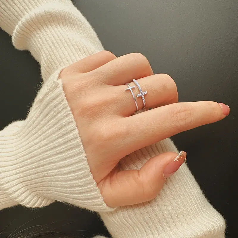 Double Christian cross ring with diamonds on finger of woman