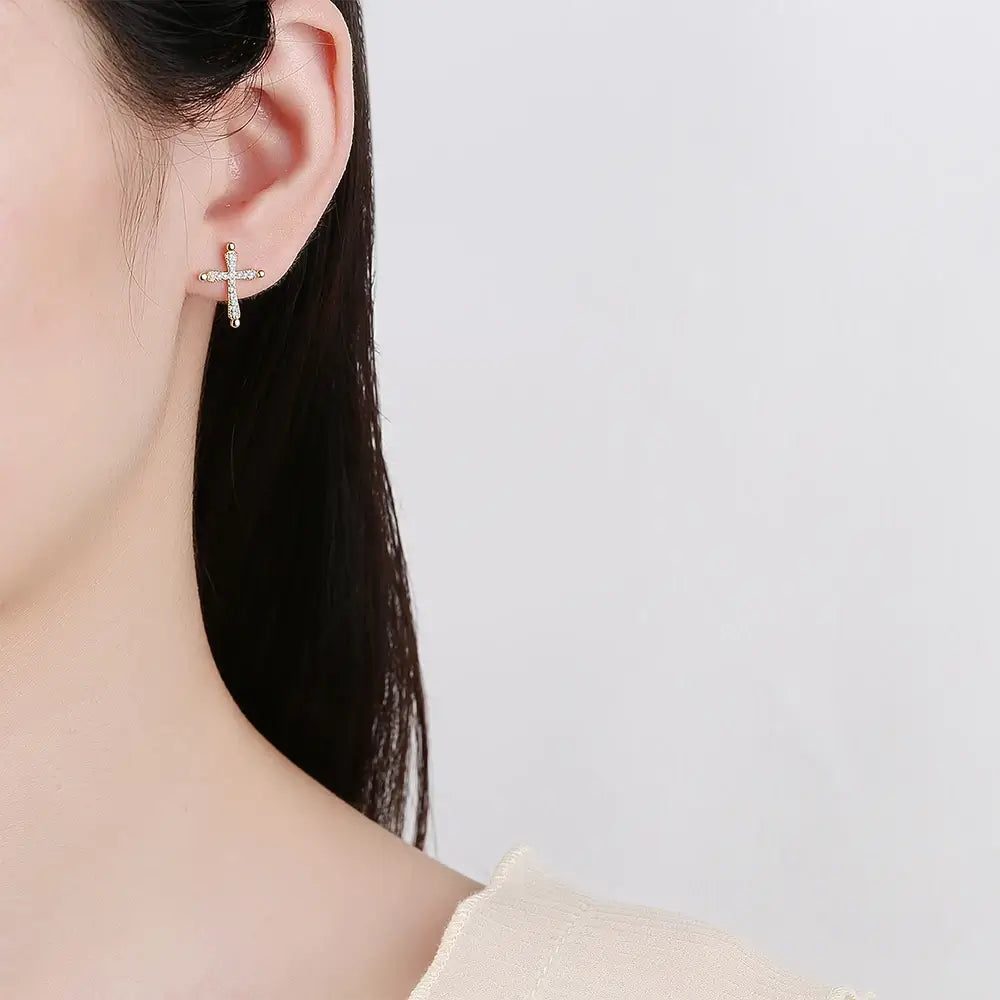 Earrings with a Christian cross in gold on woman